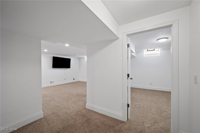 below grade area featuring recessed lighting, baseboards, and carpet