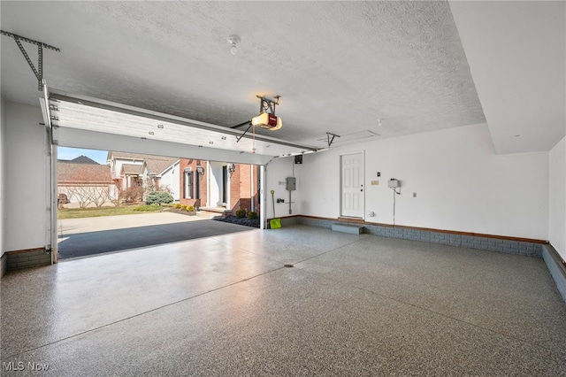 garage with baseboards and a garage door opener