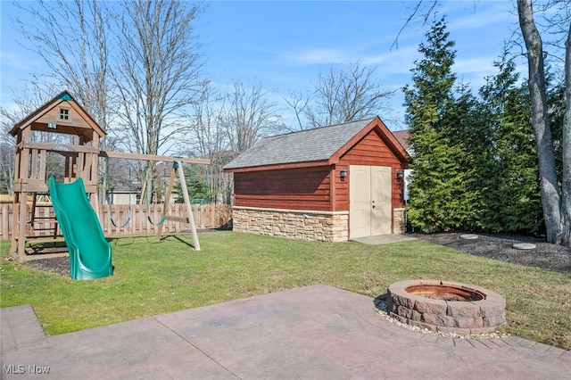 exterior space with an outbuilding, fence, an outdoor fire pit, a storage shed, and a playground