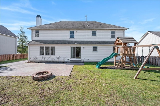 back of house with a playground, a patio area, fence, and a lawn