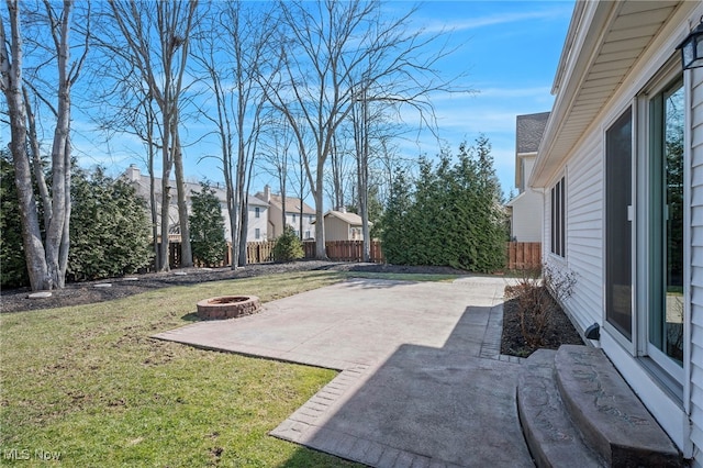 view of yard featuring a patio, a fire pit, and fence