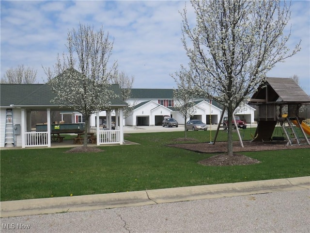 view of property's community with a gazebo, playground community, a detached garage, and a lawn