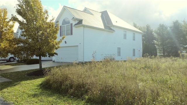 view of side of property with driveway and a garage