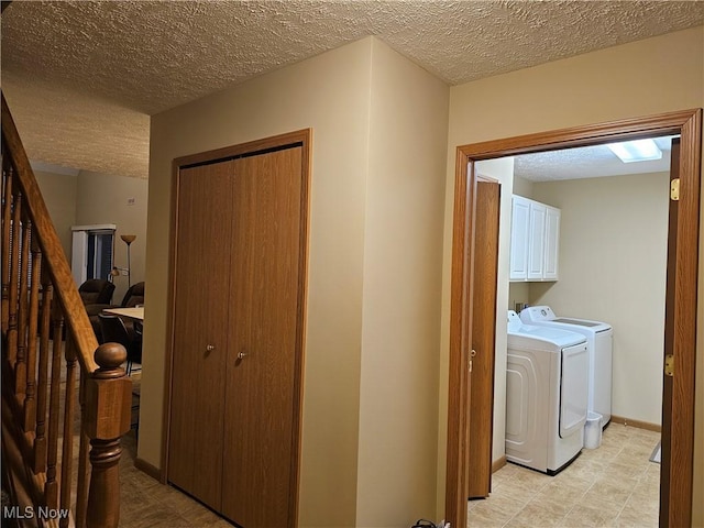 corridor with stairway, baseboards, a textured ceiling, and washing machine and clothes dryer