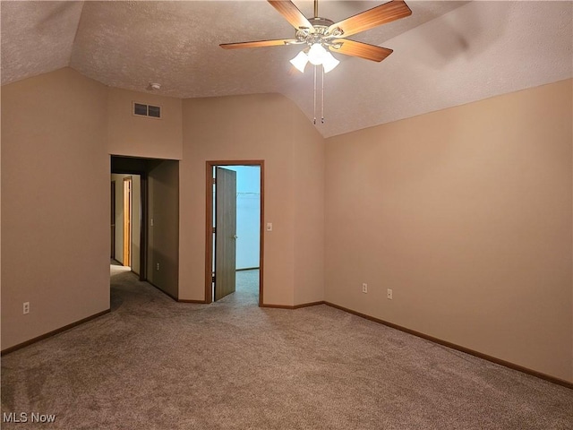 carpeted empty room with visible vents, baseboards, lofted ceiling, a textured ceiling, and a ceiling fan