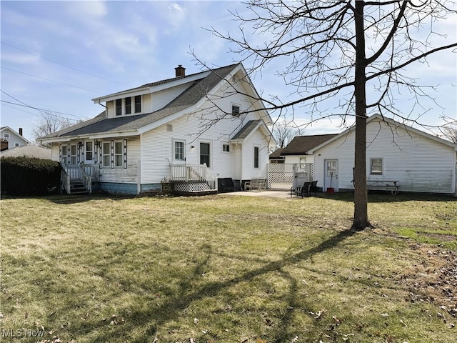 back of house featuring a yard, fence, and a chimney