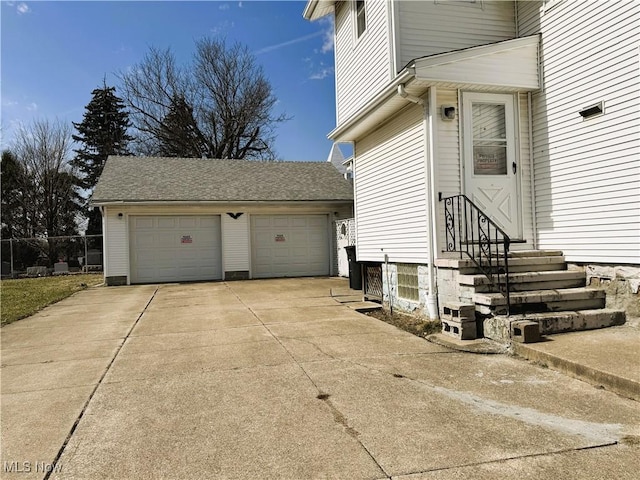 view of side of home featuring entry steps, an outdoor structure, and a garage