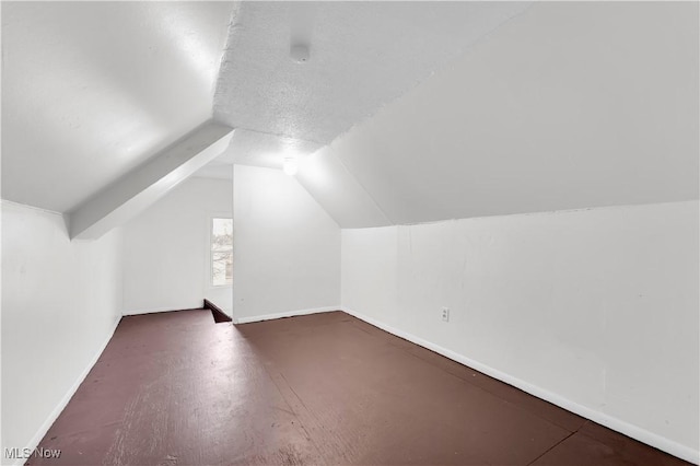 bonus room featuring vaulted ceiling and baseboards