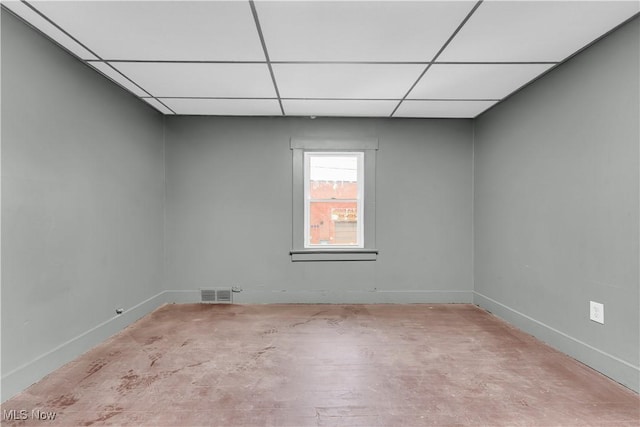 empty room featuring a drop ceiling, baseboards, and visible vents