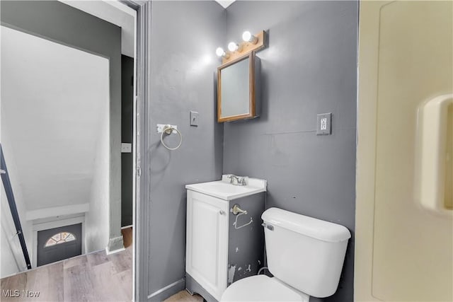 bathroom featuring wood finished floors, toilet, and a sink