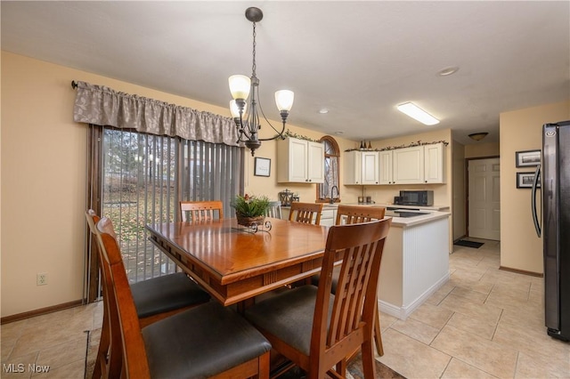 dining space featuring a notable chandelier and baseboards