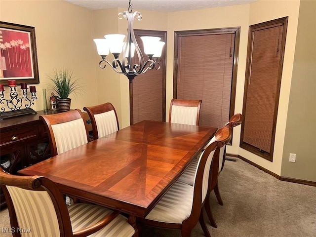 dining area with baseboards, carpet, and a chandelier