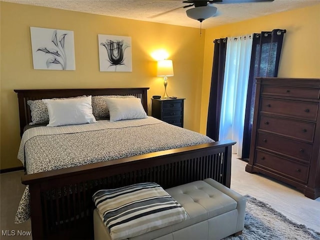 bedroom with light colored carpet and a textured ceiling