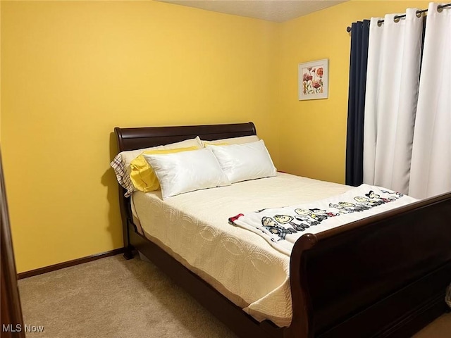 carpeted bedroom featuring baseboards