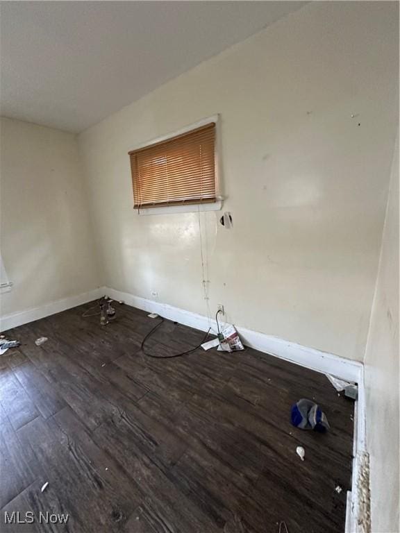 unfurnished room with baseboards and wood finished floors