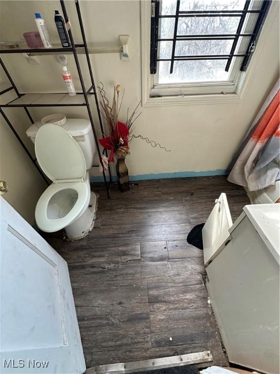 bathroom featuring hardwood / wood-style floors, toilet, and baseboards