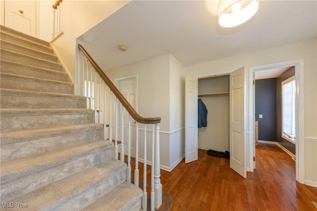 staircase featuring wood finished floors and baseboards