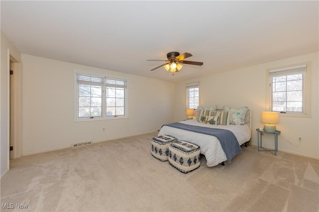 bedroom featuring visible vents, multiple windows, and carpet