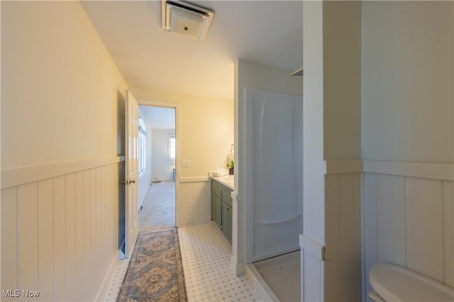 full bathroom featuring a wainscoted wall, toilet, and vanity