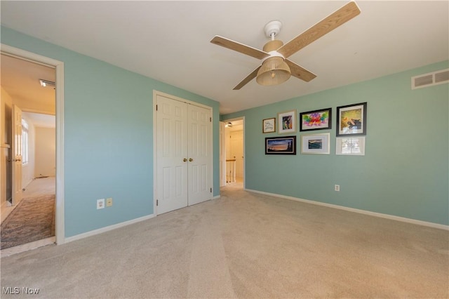 unfurnished bedroom with visible vents, ceiling fan, baseboards, carpet, and a closet