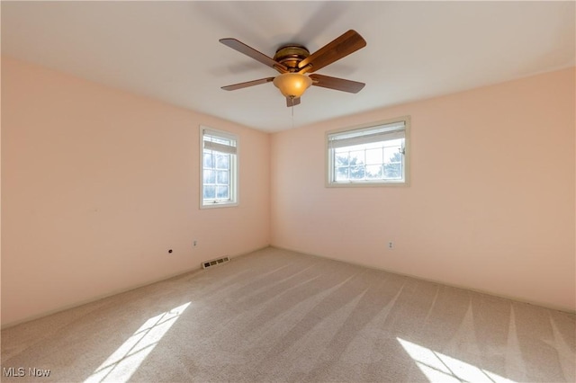 unfurnished room featuring visible vents, carpet flooring, and ceiling fan