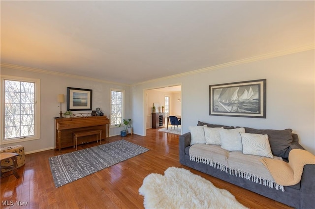 living room featuring a healthy amount of sunlight, ornamental molding, and wood finished floors