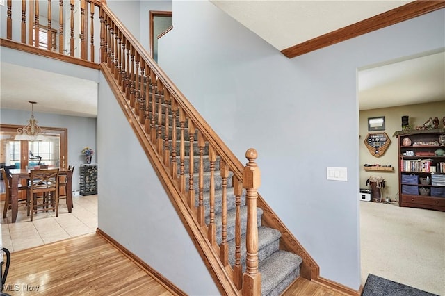 stairs with wood finished floors, baseboards, and a towering ceiling