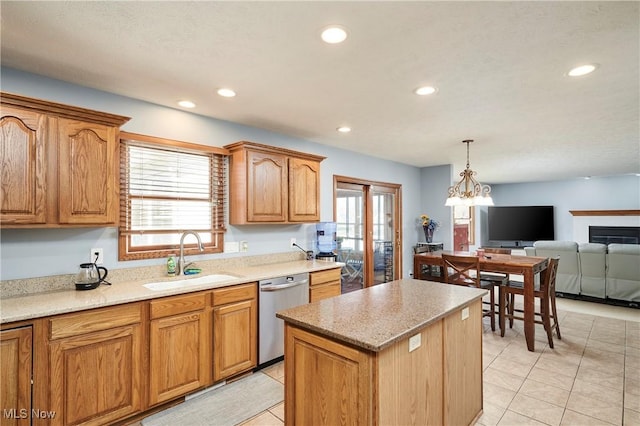 kitchen with a center island, open floor plan, stainless steel dishwasher, hanging light fixtures, and a sink