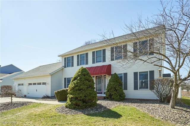 colonial-style house with an attached garage and concrete driveway