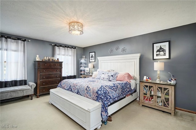 carpeted bedroom with a textured ceiling and baseboards