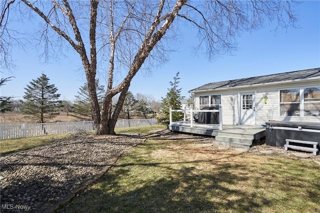 view of yard featuring a hot tub, a deck, and fence