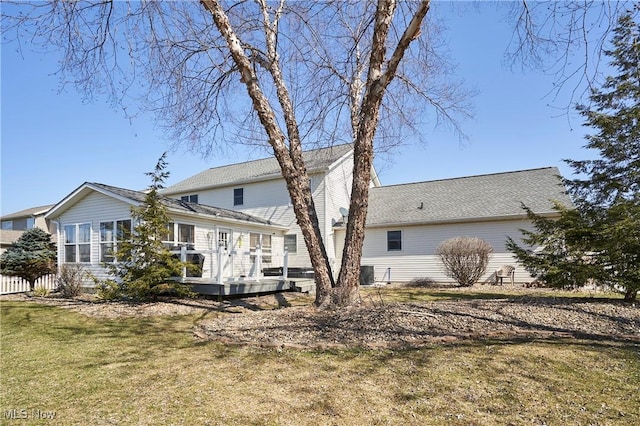 back of property featuring a deck, cooling unit, and a lawn