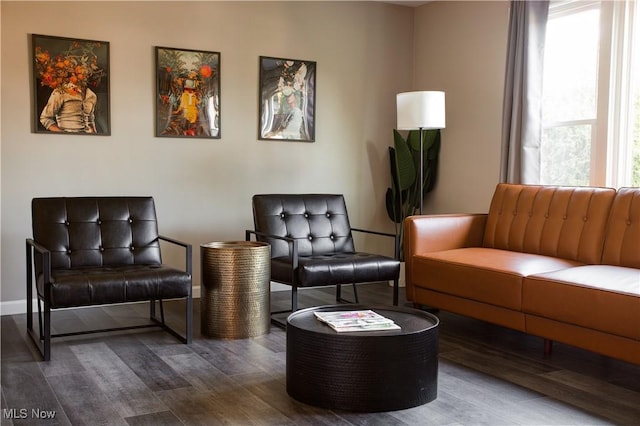 living area with baseboards and wood finished floors