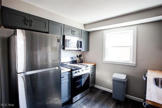 2448 Warrensville Center Rd, University Heights, OH 44118 - kitchen with stainless steel appliances, light countertops, baseboards, and dark wood-style flooring