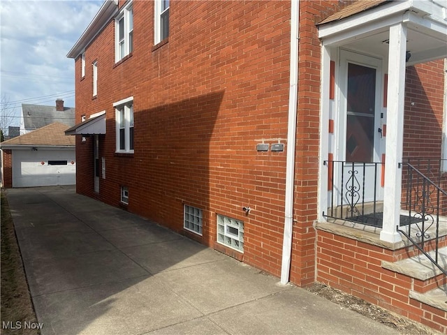 2448 Warrensville Center Rd, University Heights, OH 44118 - view of side of property featuring an outbuilding, a garage, and brick siding