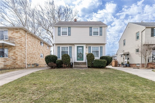 colonial inspired home featuring entry steps and a front yard