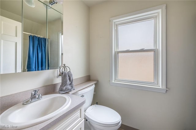 full bath with toilet, vanity, and a shower with shower curtain