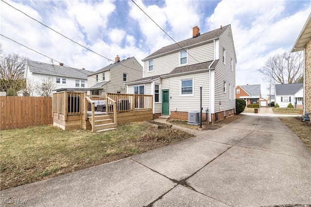 rear view of house featuring central AC, fence, a yard, a wooden deck, and a chimney