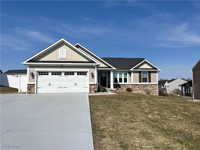 craftsman-style home featuring a garage, stone siding, board and batten siding, and driveway