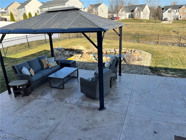 view of patio / terrace with a gazebo, an outdoor living space, a fenced backyard, and a residential view