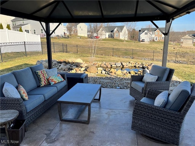 view of patio / terrace with a gazebo, a residential view, an outdoor living space, and a fenced backyard