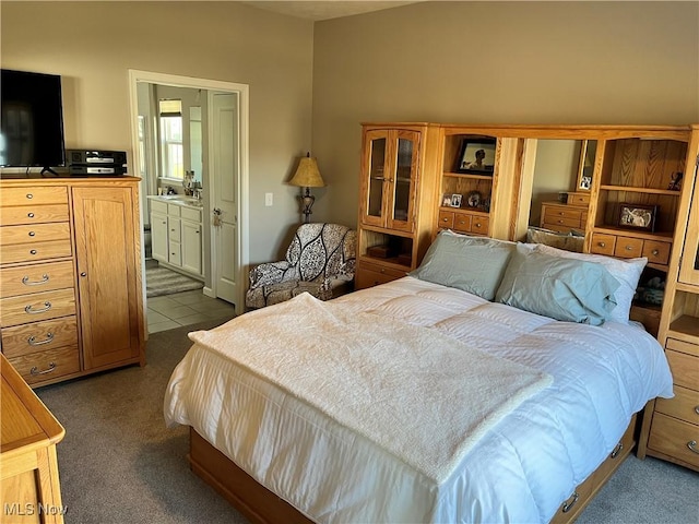 bedroom with ensuite bath and dark carpet