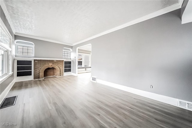 unfurnished living room featuring visible vents, a fireplace, baseboards, and ornamental molding