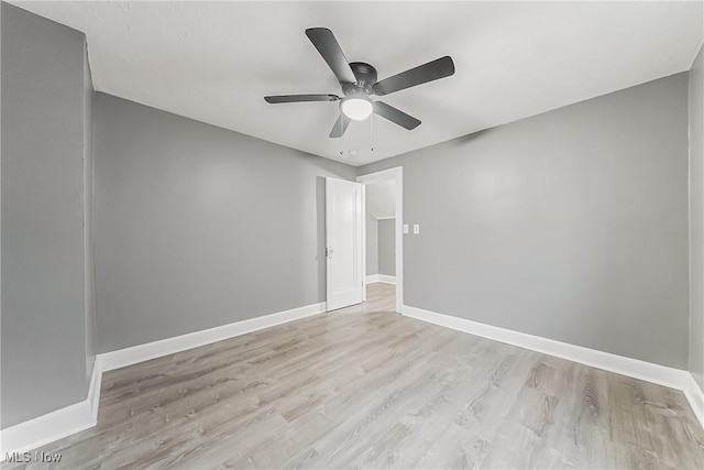 spare room featuring wood finished floors, baseboards, and ceiling fan