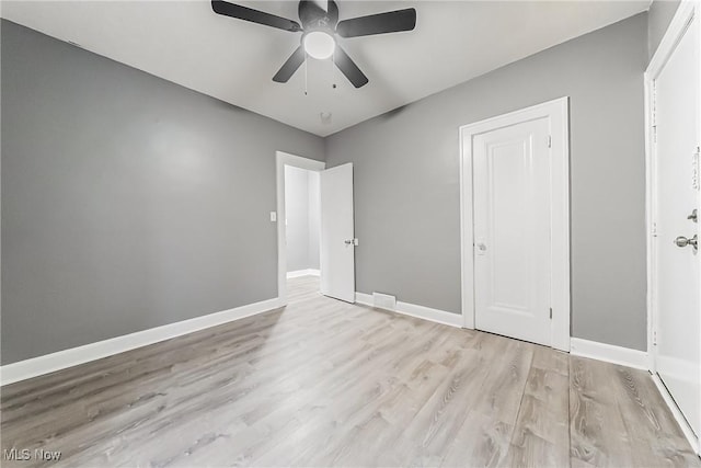 unfurnished bedroom with baseboards, wood finished floors, and a ceiling fan