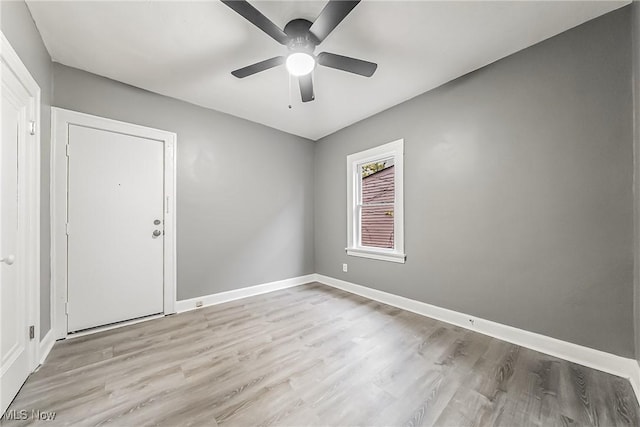 empty room with ceiling fan, baseboards, and wood finished floors