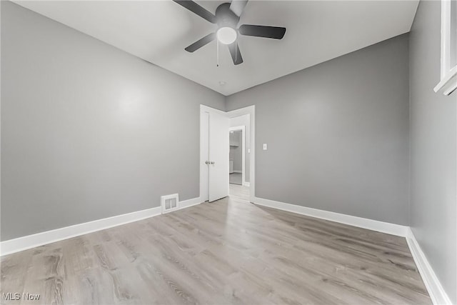 unfurnished room with light wood-style floors, baseboards, visible vents, and ceiling fan