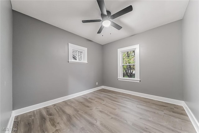 unfurnished room with a ceiling fan, wood finished floors, and baseboards