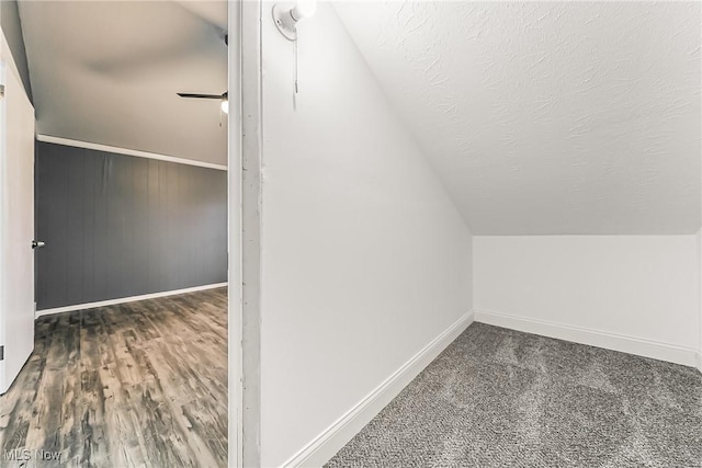 bonus room with baseboards, lofted ceiling, and a textured ceiling