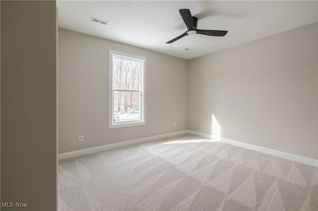unfurnished room with light carpet, baseboards, and a ceiling fan